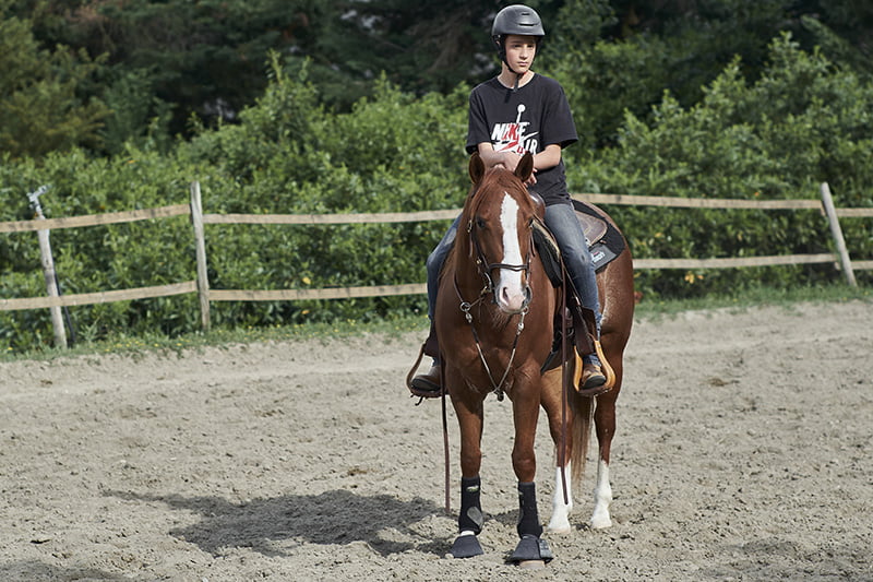 Bambino a cavallo con casco per equitazione Il Ranch Bologna